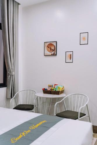 a room with a table and two chairs and a table with a table at Catba SunWoo Homestay & Hotel in Cat Ba