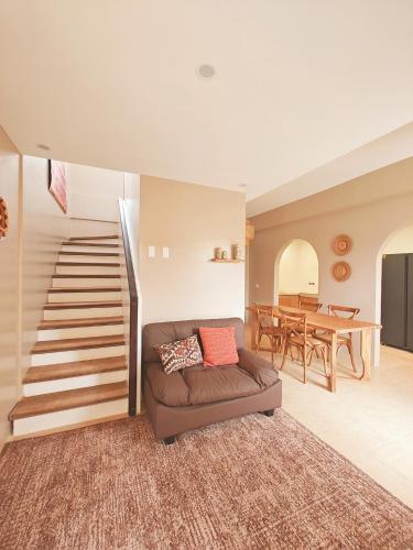 a living room with a couch and a staircase at The Ubuntu House in Dauis