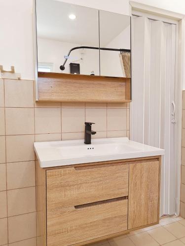 a bathroom with a sink and a mirror at The Ubuntu House in Dauis