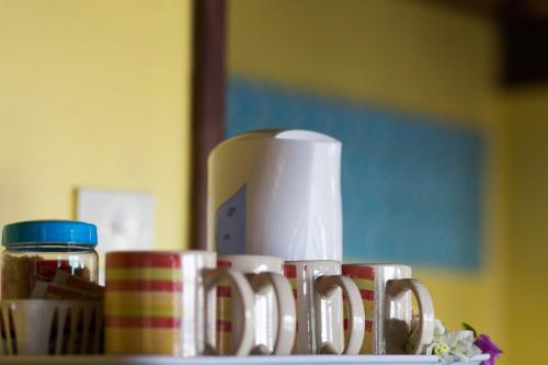 a group of coffee cups on a table with a toaster at Funky Fish Beach & Surf Resort in Malolo