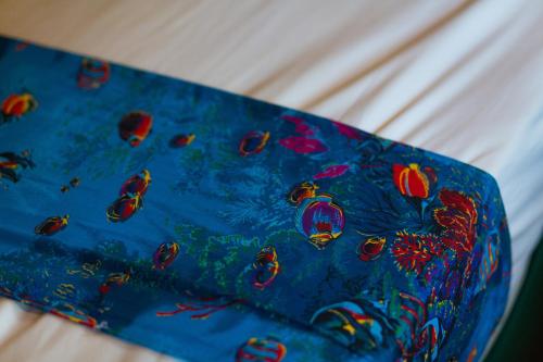 a blue towel with fish on it on a bed at Funky Fish Beach & Surf Resort in Malolo