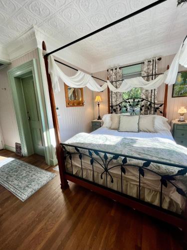 a bedroom with a bed with a canopy at Historic Devoe House-Walk to Downtown Arts and Restaurants in Wausau