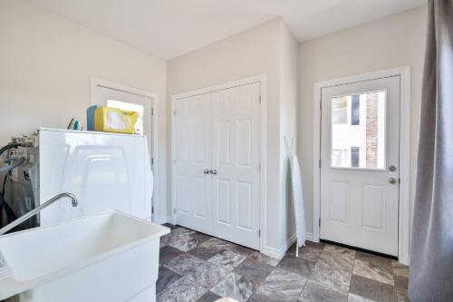 une cuisine avec un évier et un réfrigérateur blanc dans l'établissement Spacious 4Bdrm Home | Patio, BBQ, Walk to Lake, à Fenelon Falls