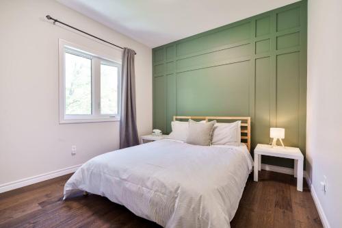 - une chambre dotée d'un lit avec un mur vert dans l'établissement Spacious 4Bdrm Home | Patio, BBQ, Walk to Lake, à Fenelon Falls