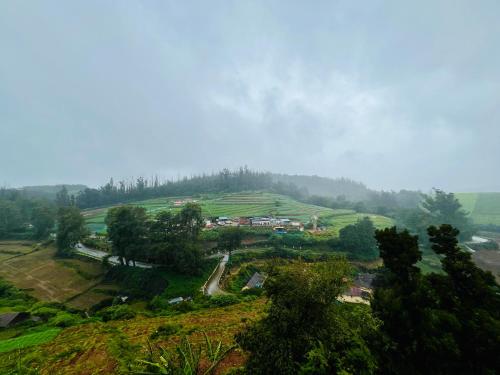 a view of a hill with a village on it at Away From Home - 10 - Rooms In Ooty, Home Stay in Ooty in Ooty