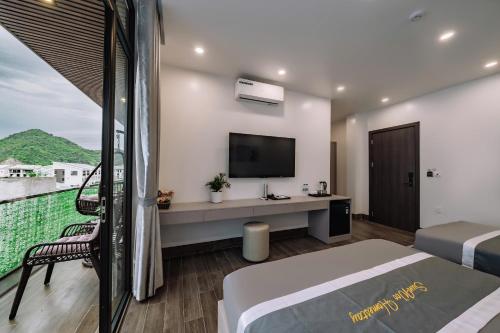 a bedroom with a bed and a tv and a balcony at Catba SunWoo Homestay & Hotel in Cat Ba