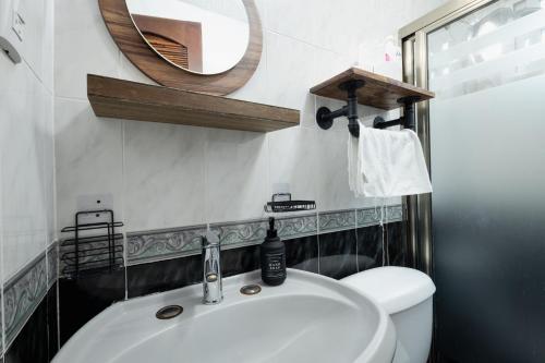 a bathroom with a sink and a mirror and a toilet at Room with shared bathroom in the heart of Cancun in Cancún