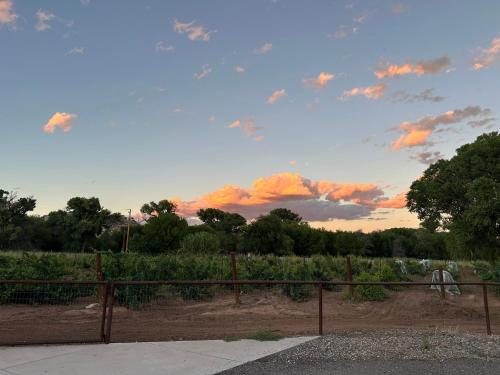 a fence in front of a field with a cloudy sky at Riesling Retreat in Cottonwood