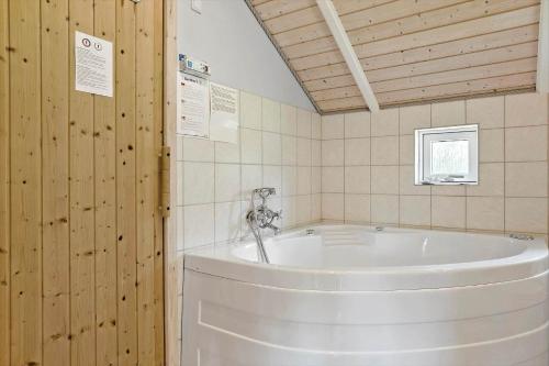 y baño con bañera grande y paredes de madera. en LF328-Vestervig-Gunhildsvej-28, en Vestervig