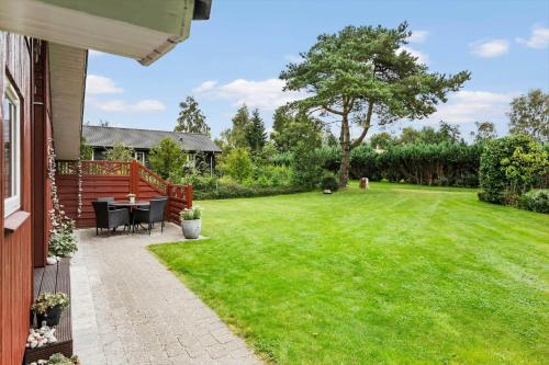 a backyard with a table and chairs on a lawn at LF15149-Farso-Ramshule-49 in Farsø