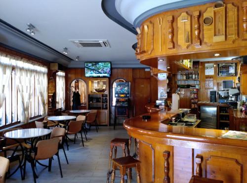 a bar in a restaurant with tables and chairs at Hostal Romi in Cantalejo