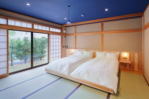 a japanese bedroom with a bed and a window at 甚兵衛邸 in Hirado