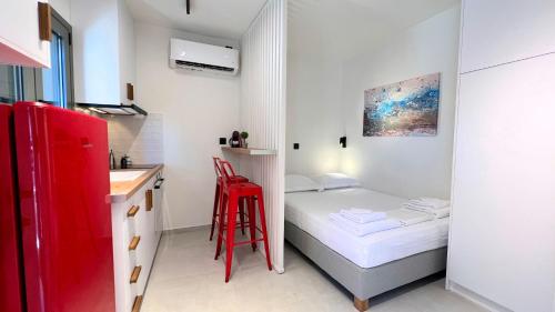 a small room with a bed and a red stool at Lemon Tree Studio 1 in Mytilini