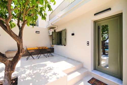 a patio with a tree next to a building at Lemon Tree Studio 1 in Mytilini