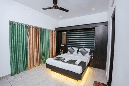 a bedroom with a large bed with green curtains at Cardamom Crush Premium Villa in Munnar