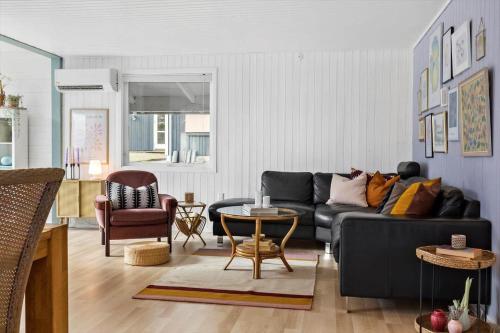 a living room with a black couch and a table at LF15233-Hojslev-Jelsevej-261 in Højslev