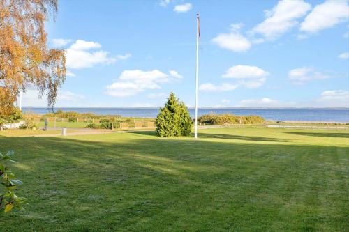 a grassy field with a flag pole and the ocean at LF15233-Hojslev-Jelsevej-261 in Højslev