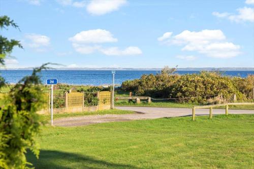 a road next to a field with the ocean at LF15233-Hojslev-Jelsevej-261 in Højslev