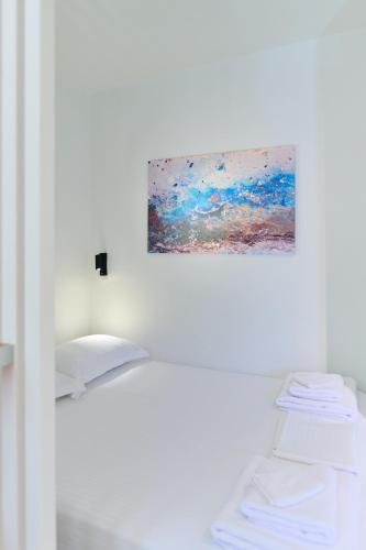 a painting hanging on a wall next to a bed at Lemon Tree Studio 1 in Mytilini