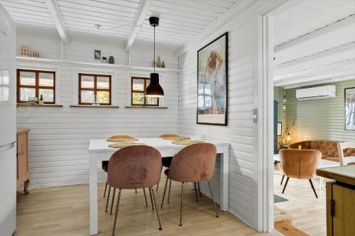 a dining room with a white table and chairs at LF14163-Roslev-Kybehuse-3 in Roslev