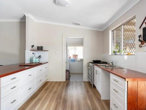 a kitchen with white cabinets and a wooden floor at 1915 cottage renovated and ready in Boulder