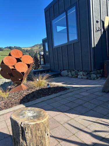 a house with a tree stump in front of it at Harbour Hideaway in Dunedin