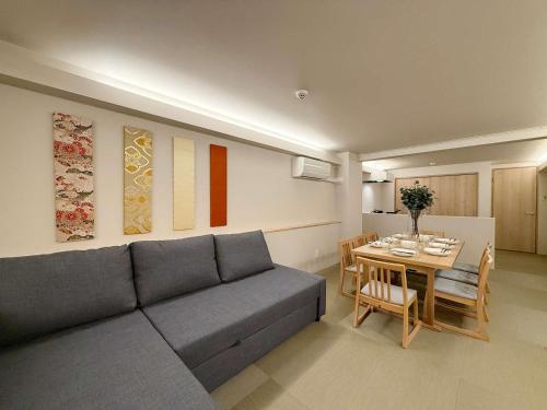 a living room with a couch and a table at b hotel Miyajima Omotesando - Sacred Island Stay 21 in Miyajima