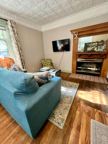 a living room with a blue couch and a fireplace at Historic Devoe House-Walk to Downtown Arts and Restaurants in Wausau
