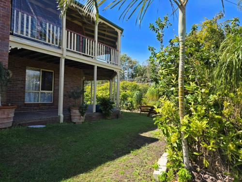a house with a yard with a tree at SoKo Holiday Apartment in Agnes Water