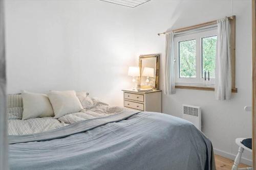 een witte slaapkamer met een bed en een raam bij LF10318-Hurup-Thy-Sortmejsevej-2 in Sønder Ydby