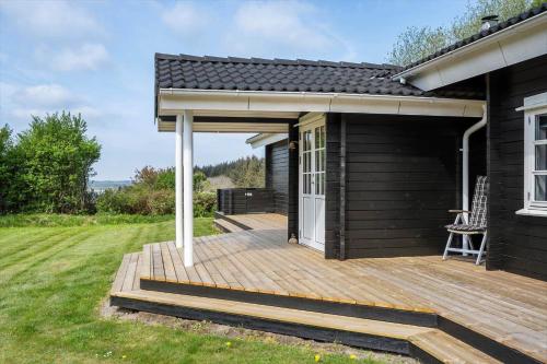 a house with a wooden deck in the yard at LF15023-Skals-Lynderup-Strand-2 in Skals