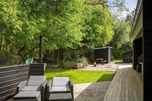 a patio with two chairs and a fire hydrant in a yard at LF15023-Skals-Lynderup-Strand-2 in Skals