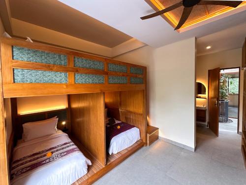 a bedroom with a bunk bed in a room at Leafy Riverbank in Tabanan