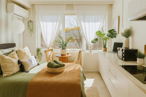 a room with a bed and a kitchen with a window at Stylish Studio at heart of St Kilda in Melbourne