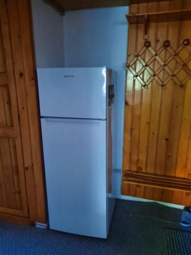 a white refrigerator in a kitchen with wooden cabinets at DÉNY APARTMAN in Sfântu-Gheorghe