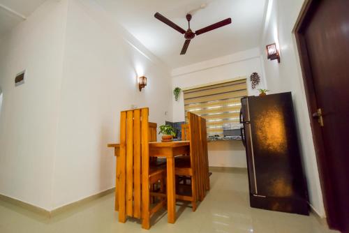 a kitchen with a table and a refrigerator at Sharasvee Nature Villa in Talalla