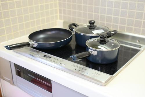 two pots and pans sitting on top of a stove at グッドタイム新城 in Aomori