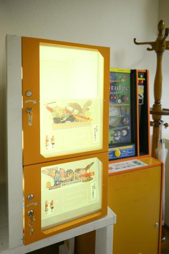 a cabinet with two pictures on it next to a machine at グッドタイム新城 in Aomori
