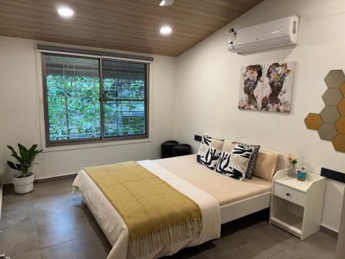 a bedroom with a large bed and a window at Villetta, cozy and uber modern cottage. in Pune