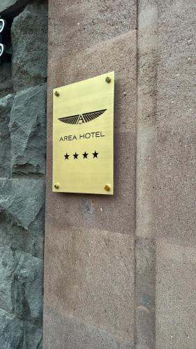 a sign for aarea hotel on a stone wall at AREA Hotel Yerevan in Yerevan
