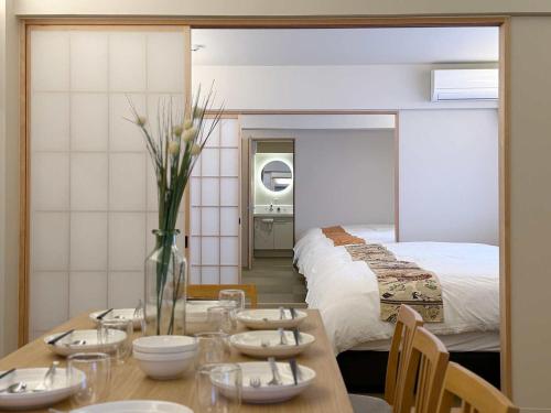 a dining room with a table and a bed at b hotel Miyajima Omotesando - Sacred Island Stay 22 in Miyajima