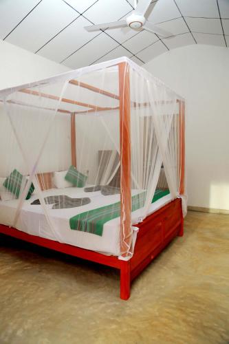 a bedroom with a canopy bed in a room at Hiriketiya Suka Place in Hiriketiya