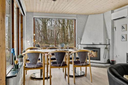 a dining room with a table and chairs and a fireplace at LF14301-Roslev-Vollebjergvej-1 in Roslev