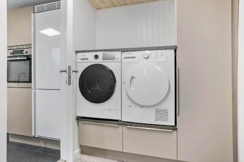 a washer and dryer in a white kitchen at LF14301-Roslev-Vollebjergvej-1 in Roslev