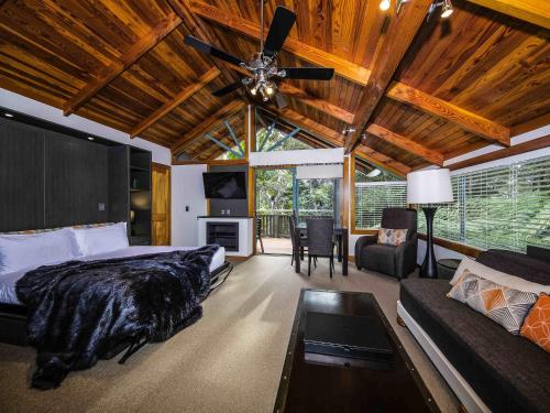 a bedroom with a bed and a ceiling fan at Grand Mercure Puka Park Resort in Pauanui