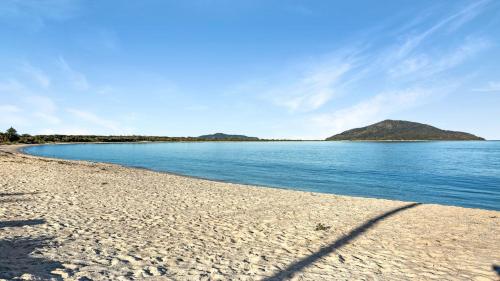 ein Blick auf einen Strand mit Bergen im Hintergrund in der Unterkunft 2 - 76 Mirreen Street Hawks Nest in Hawks Nest