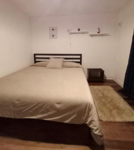 a bedroom with a large bed with a white bedspread at Wind Guest House in Valparaíso