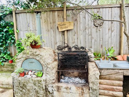 an outdoor kitchen with a sink and a fence at Cabaña del Bosque de Laguna Verde in Valparaíso
