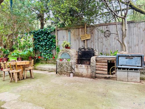 a backyard with a grill and a wooden fence at Cabaña del Bosque de Laguna Verde in Valparaíso