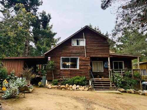 a wooden house with a porch and stairs to it at Cabaña del Bosque de Laguna Verde in Valparaíso